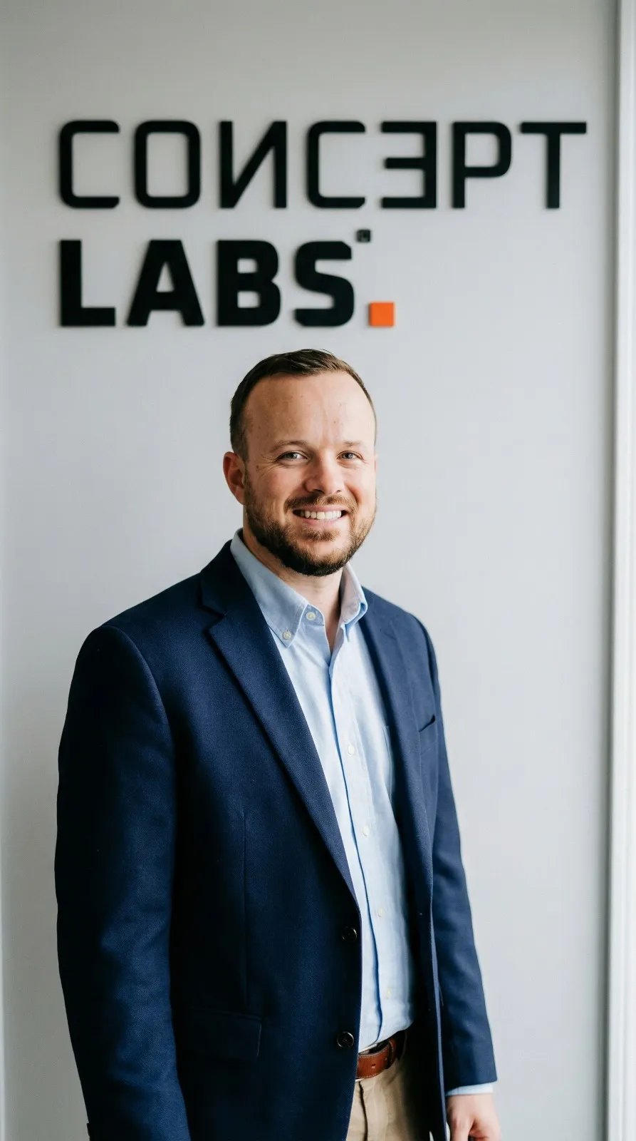 Theuno de Bruin, founder of ConceptLABS, in navy blazer with the ConceptLABS logo behind him